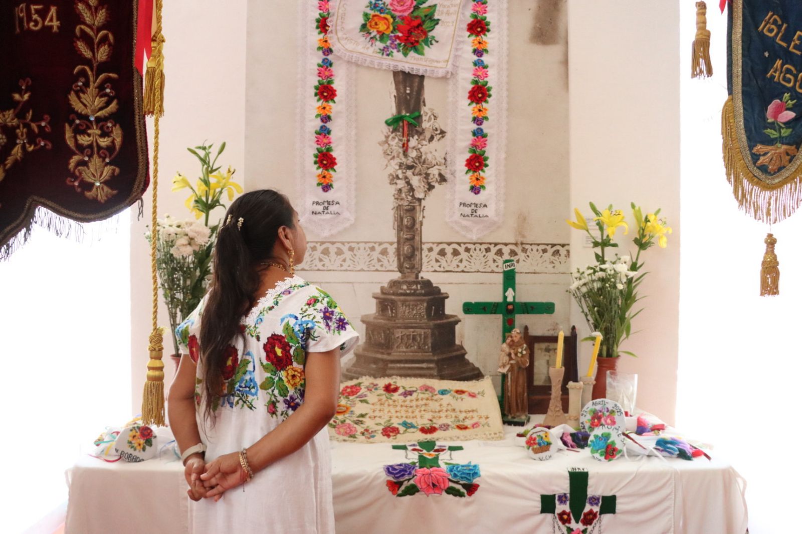 Estandartes bordados en hilos de oro, prendas rituales y textiles que narran la fe y tradiciones mayas.
